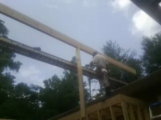 Carpenter setting a ridge beam over a new addition frame — Ice Dam Removal by Roofing Brothers in Glen Flora