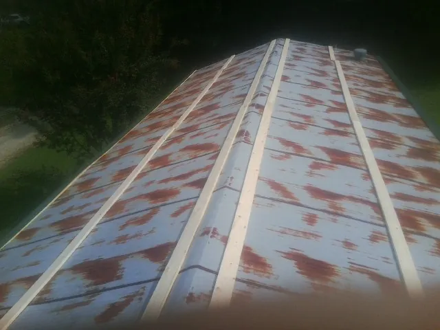 Rusted metal roof panels with new wood purlins before replacement — Storm Damage Roof Repair in Glen Flora by Roofing Brothers