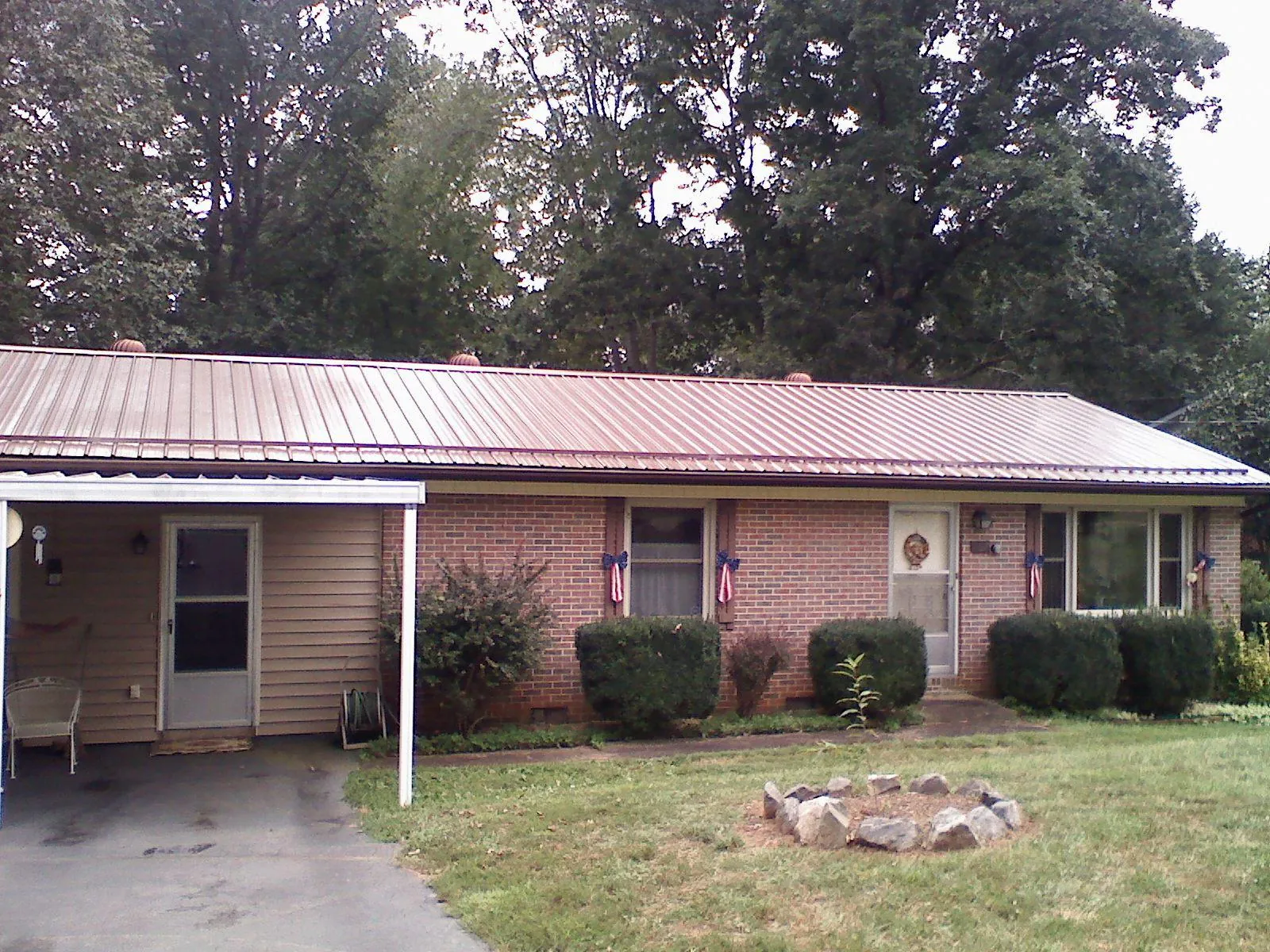 Bronze metal roof and carport on a brick ranch home — Roof Repair work by our crew in Glen Flora